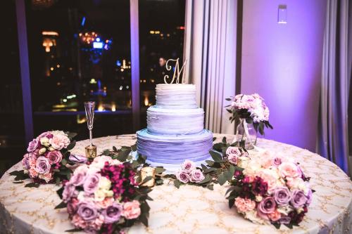 a wedding cake sitting on top of a table with flowers at DoubleTree by Hilton New Orleans in New Orleans