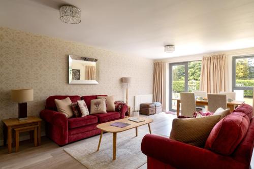 a living room with two red couches and a table at The Highland Club in Fort Augustus