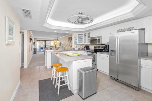 a kitchen with white cabinets and a stainless steel refrigerator at Pointe Santo B32 condo in Sanibel
