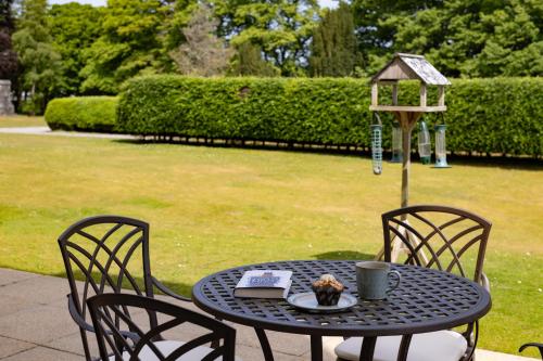 a table with a bird house and a plate of food on it at The Highland Club in Fort Augustus