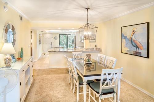 a dining room and kitchen with a table and chairs at Pointe Santo D27 condo in Sanibel