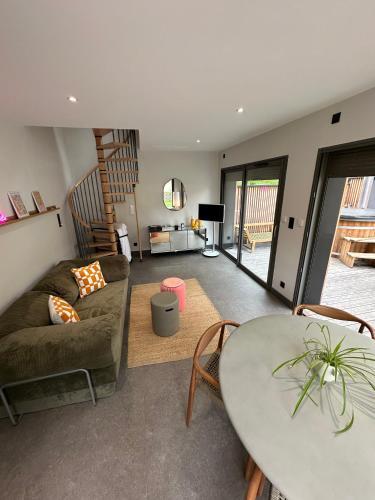 un salon avec un canapé et une table dans l'établissement Ancien Pigeonnier Centre-Ville historique de Vesoul Bain nordique Terrasse Jardin Animaux bienvenus, à Vesoul