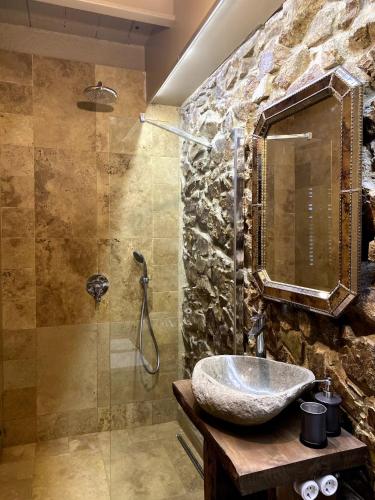 a stone bathroom with a sink and a shower at Stone Rustic Beach apartment in Blanes