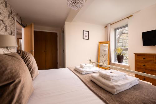 a bedroom with towels on a bed with a window at The Highland Club in Fort Augustus