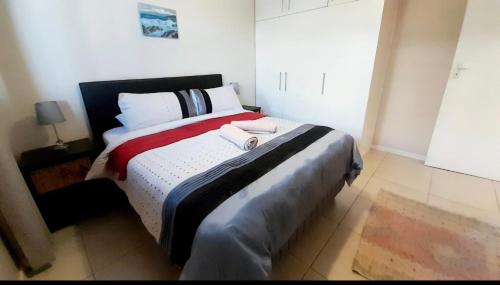 a bedroom with a bed with two towels on it at 84 Camarque Umdloti beach in Umdloti