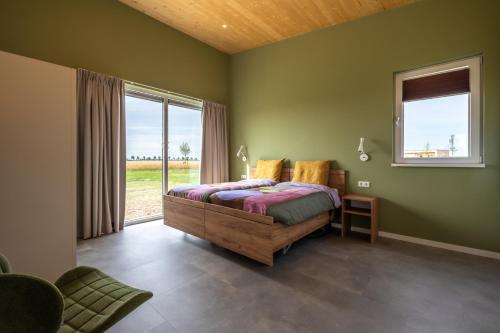 Un dormitorio con una cama y una ventana grande. en Landgoed Oud Bommenede, en Zonnemaire