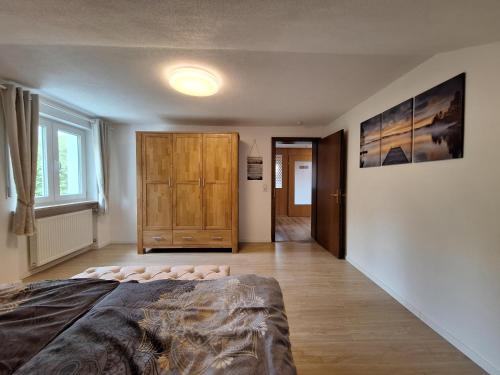 a bedroom with a bed and a wooden cabinet at Haus Seeglück in Taching am See