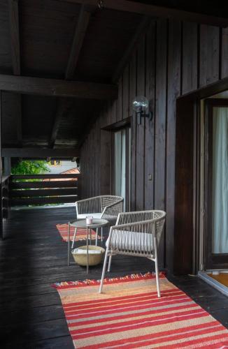two chairs and a table on a deck at Ferienhaus Fringaluna in Übersee