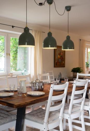 a dining room with a wooden table and white chairs at Ferienhaus Fringaluna in Übersee