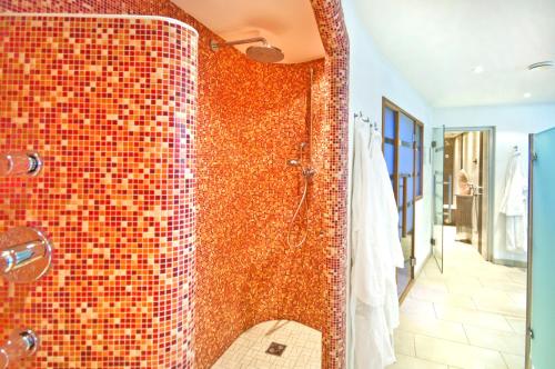 a bathroom with a shower with a mosaic tile wall at Landhaus Zaglauhof in Werfenweng