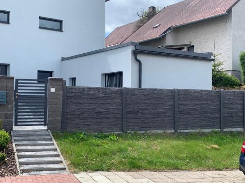 a fence in front of a house with a house at Apartmány TERA in Miletín