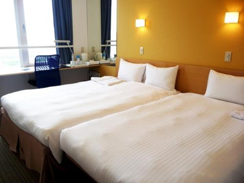 two large beds in a hotel room with at Smile Hotel Sendai Tagajyo - Vacation STAY 84269v in Tagajo