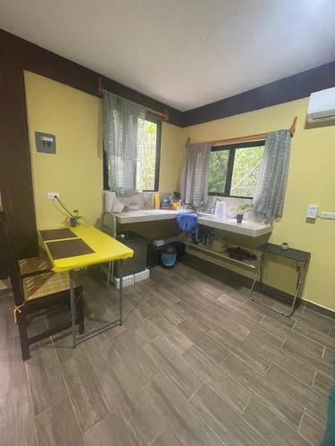 a room with two sinks and a yellow wall at Cabañas Xpujil Calakmul Campeche con vista a la Selva in Xpujil