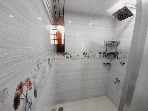 a bathroom with a shower with dogs on the wall at Hill View Tower, Sylhet, Shah Poran, Sylhet in Debpur