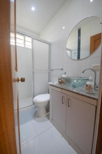 a white bathroom with a toilet and a sink at edificio Alba in Cartagena de Indias
