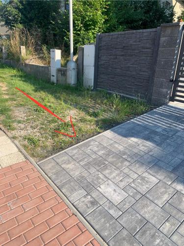 a brick sidewalk with a red cord on the grass at Apartmány TERA in Miletín