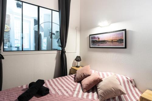 une chambre avec un lit avec des oreillers et une fenêtre dans l'établissement AppartementT1 -Palais de Justice, à Toulouse