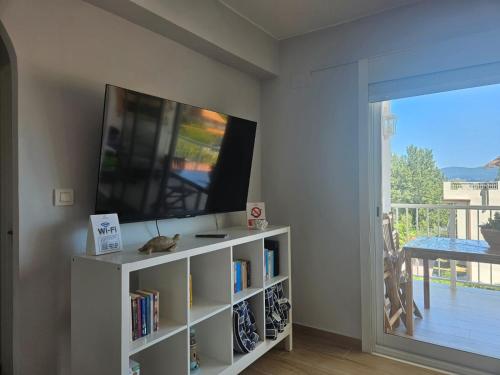 un soggiorno con TV e libreria di Frente al Mar Primera Linea de Playa Samil a Vigo