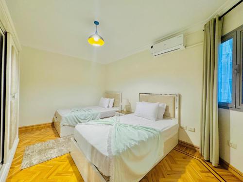 a bedroom with two beds and a window at ALEX HOMES - Gleem Luxury Apartments with Direct Sea View in Alexandria