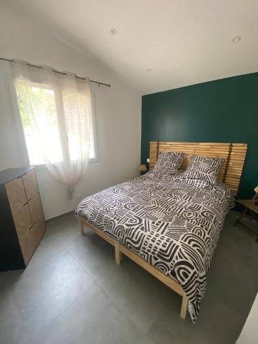 a bedroom with a bed with a black and white comforter at Les Baraquettes de St clair in Sète