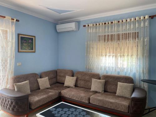 a living room with a brown couch and blue walls at Berti Apartaments in Sarandë