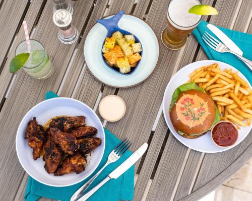 a table with three plates of food and french fries at Hyatt Regency Clearwater Beach Resort & Spa in Clearwater Beach