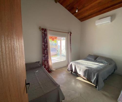 Casa Vermelha Corumbau في كورومباو: غرفة نوم بها سرير ونافذة