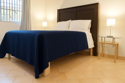 a bedroom with a bed with a blue blanket on it at EDISÓN 81 Unidades de renta habitacional in Morelia
