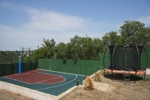 a basketball hoop and a tennis court on a fence at Kosmajko in Koraćica