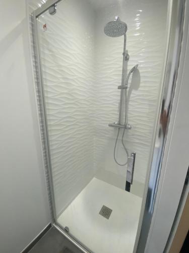 a shower stall with a shower head and a shower at Les Baraquettes de St clair in Sète