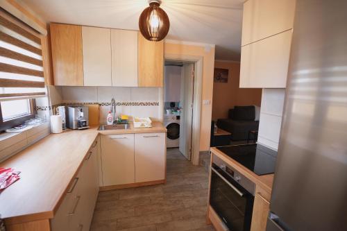 a kitchen with white cabinets and a black stove at Kosmajko in Koraćica