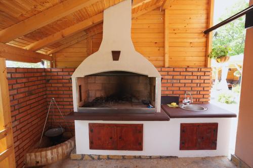 an outdoor kitchen with a fireplace in a house at Kosmajko in Koraćica