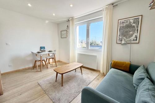 un salon avec un canapé bleu et une table dans l'établissement T1 bis rénové - Proche centre ville & plages, à Lorient