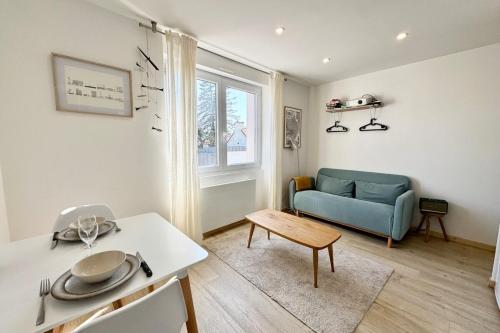un salon avec un canapé bleu et une table dans l'établissement T1 bis rénové - Proche centre ville & plages, à Lorient