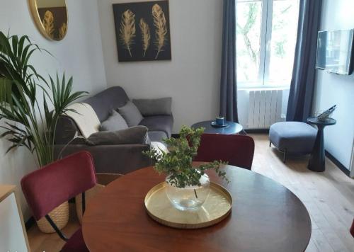 un salon avec une table et un canapé dans l'établissement T2 cosy - gare, plage et intramuros à pied, à Saint-Malo