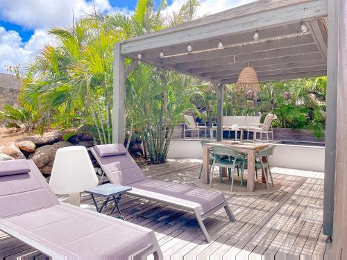 a patio with chairs and a table and a pergola at Le Lodge SXM luxe in Cul de Sac