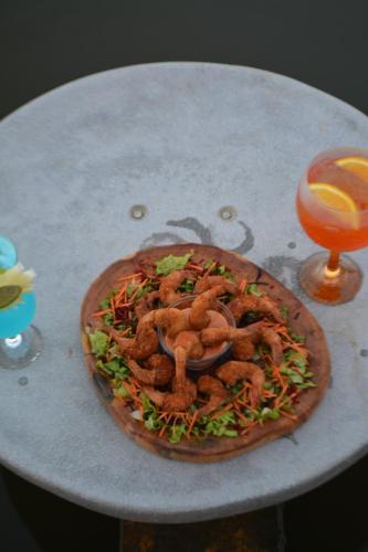 a pizza sitting on top of a table next to a glass at Chalé sítio Cumbe in Aracati