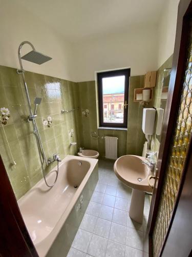 a bathroom with a tub and a toilet and a sink at Appartamento Luisa 2 in Domaso