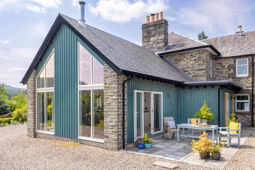 a green extension to a house with a patio at Little Pitnacree in Pitlochry