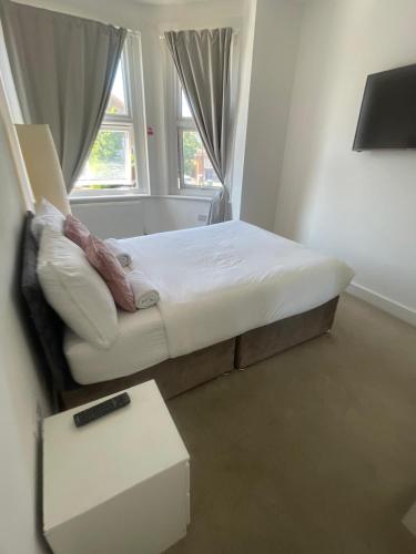 a small bedroom with a bed and a table at Stone Lodge 2 min Walk From Edgware Underground in Edgware