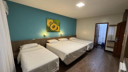 a room with two beds and a painting on the wall at Hotel das Américas in Balneário Camboriú