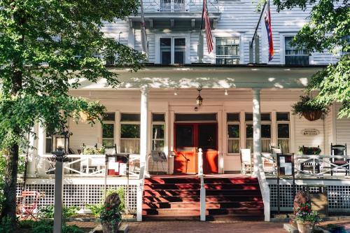 a white house with a front porch with an american flag at The Red Lion Inn in Stockbridge