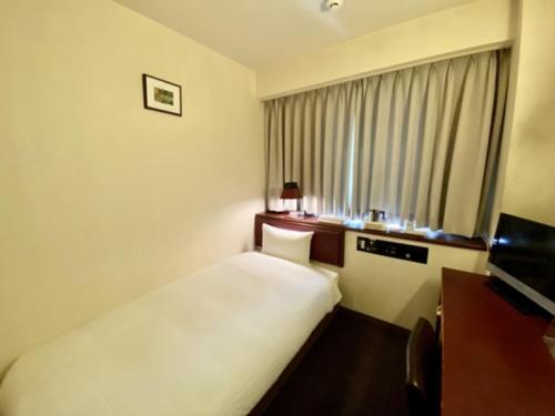 a hotel room with a white bed and a window at Smile Hotel Sasebo - Vacation STAY 92136v in Sasebo