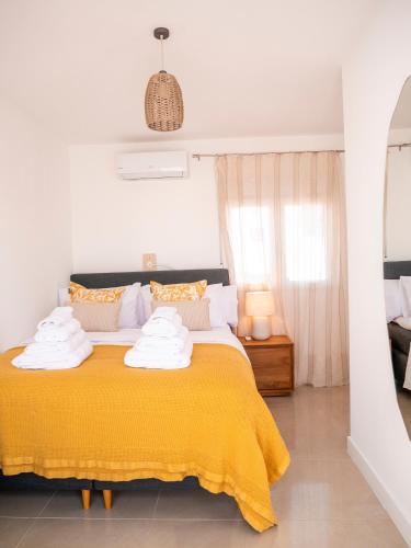 a bedroom with a yellow bed with a yellow blanket at El Pirata 78 in Estepona