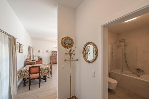 a bathroom with a shower and a toilet and a table at Villa Musik - historical apartments, Baden in Baden