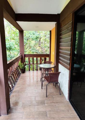 a patio with a table and chairs on a porch at Cabañas Xpujil Calakmul Campeche con vista a la Selva in Xpujil