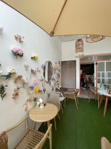 a room with tables and flowers on the wall at Hogar en Centro Ixmiquilpan in Ixmiquilpan