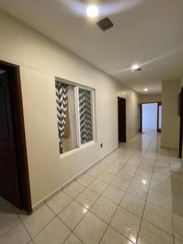 an empty hallway with a window and a tile floor at Hogar en Centro Ixmiquilpan in Ixmiquilpan