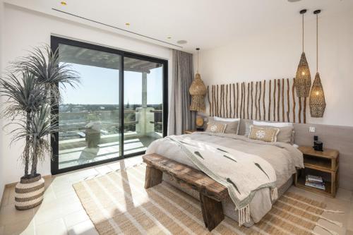 Un dormitorio con una cama y una ventana grande en Villa Avalon - Bedzy Luxury, en Almancil