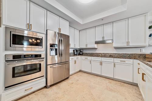 una cucina con armadietti bianchi ed elettrodomestici in acciaio inossidabile di Indigo East Unit 403W a Pensacola